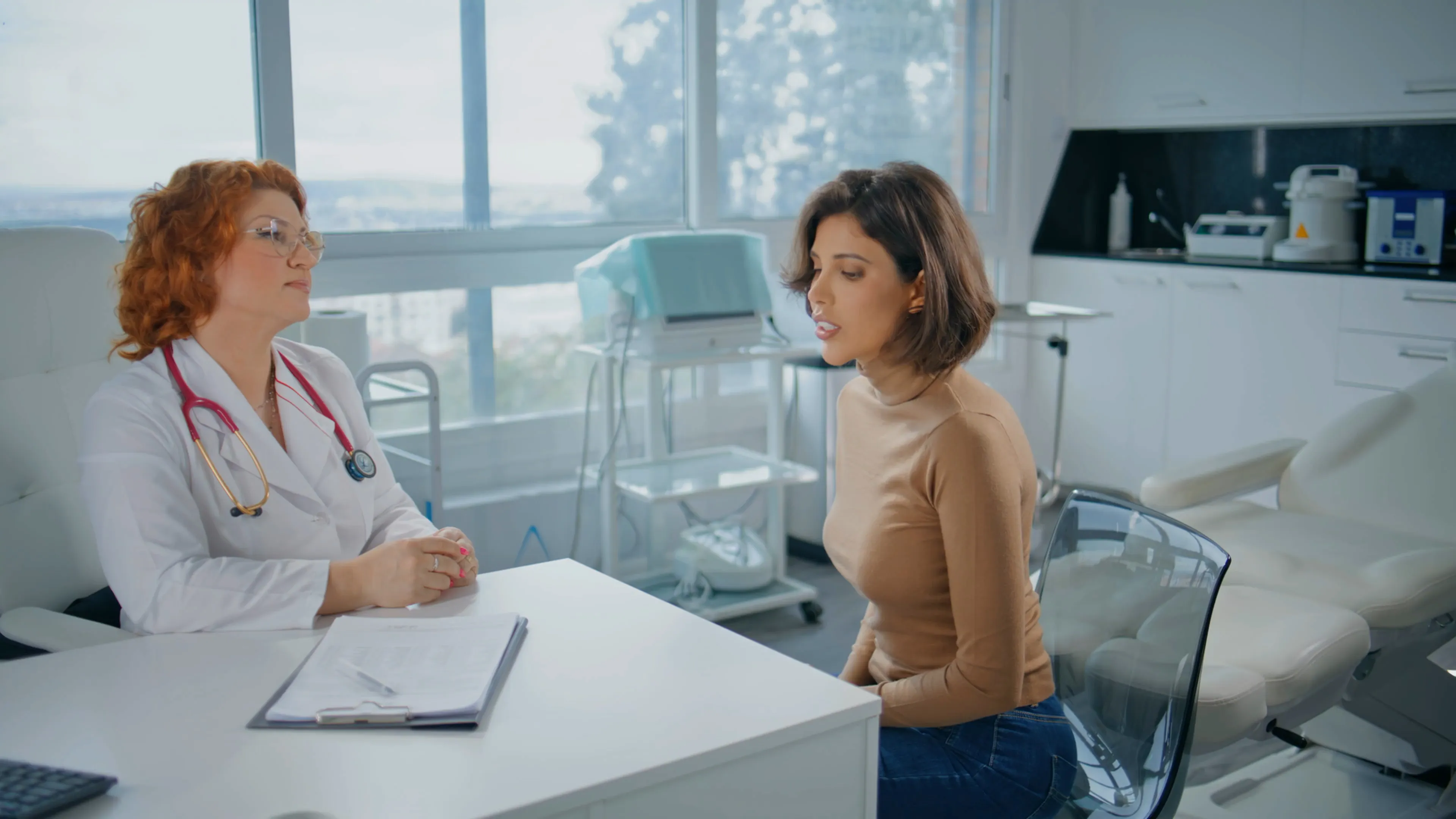 Patient describing her history to a doctor across a consulting room desk