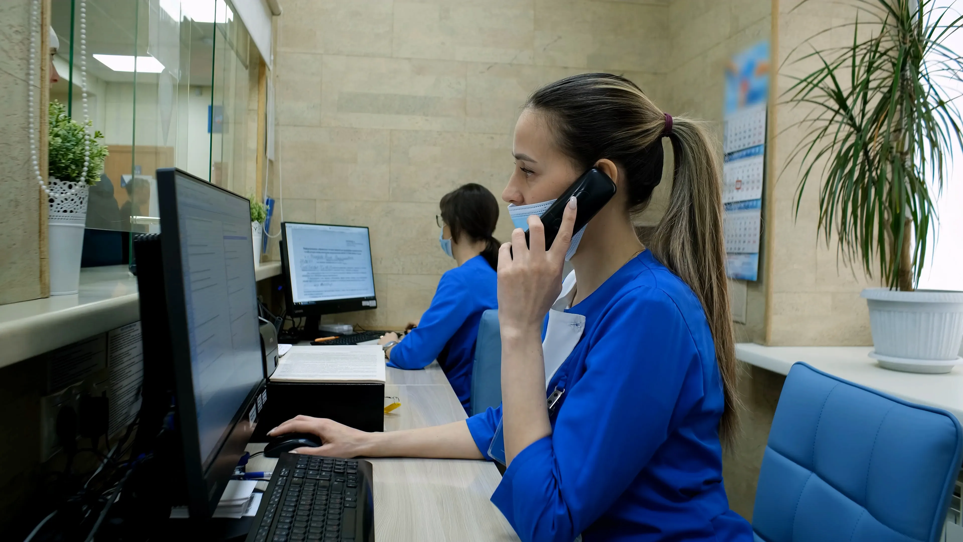Practice staff member on the phone at a reception desk
